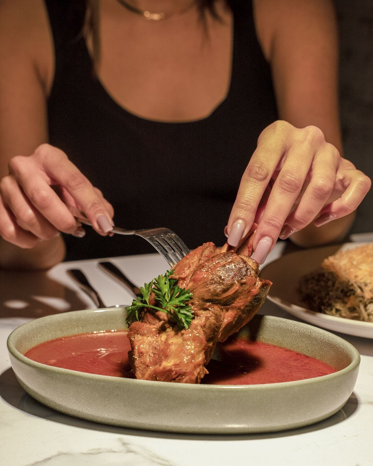 Guest serving braised lamb shank falling off the bone in Westwood Village